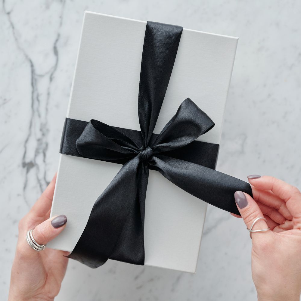 white gift box with black ribbon